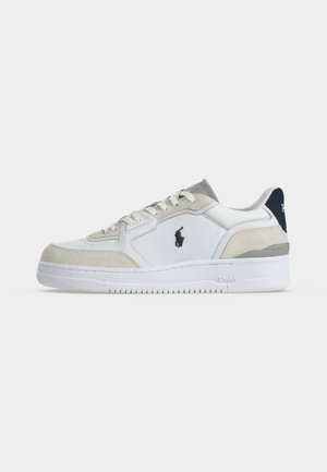 Sneaker basse bianche e beige con suola bianca, logo Polo nero sul lato e linguetta sul tallone blu navy con il nome del marchio.