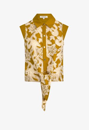 Blusa sin mangas mostaza con intrincado patrón de encaje floral blanco, botones en el frente y un detalle anudado en el dobladillo. Tejido de algodón.