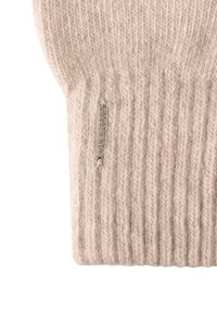Gant en maille beige avec une texture côtelée. Présente une étiquette en métal argenté avec le nom de la marque attachée au poignet. Matériau doux et chaud.