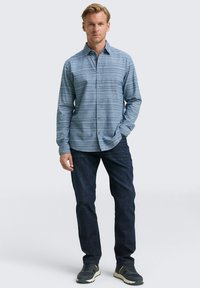 Lichtblauw overhemd met lange mouwen, horizontale strepen, knoopsluiting en een spread collar, gecombineerd met donkere jeans en sneakers.