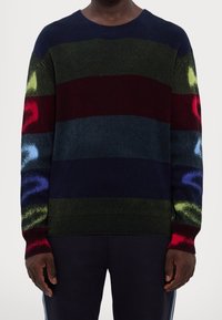 Mehrfarbiger Strickpullover mit horizontalen Streifen in Marineblau, Grün und Burgunderrot, verziert mit malerischen Akzenten in Rot, Blau und Gelb.