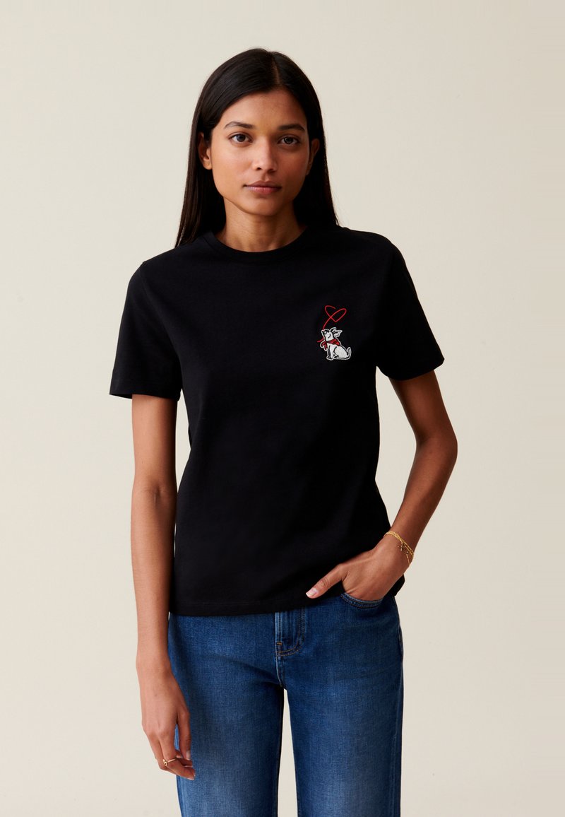 T-shirt noir en coton. Présente un petit design brodé d'un chien et d'un cœur sur la poitrine. Manches courtes et coupe classique.