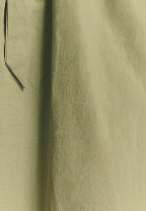 Olivovo zelená tkanina s mierne pokrčenou štruktúrou, vybavená dlhým, úzkym pások. Dizajn vykazuje jemný, plynulý štýl.