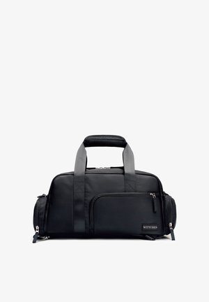 Schwarze rechteckige Reisetasche mit zwei robusten Griffen, vorderer Reißverschlusstasche, Seitenfächern und "WITTCHEN" Markenlabel in der unteren rechten Ecke.