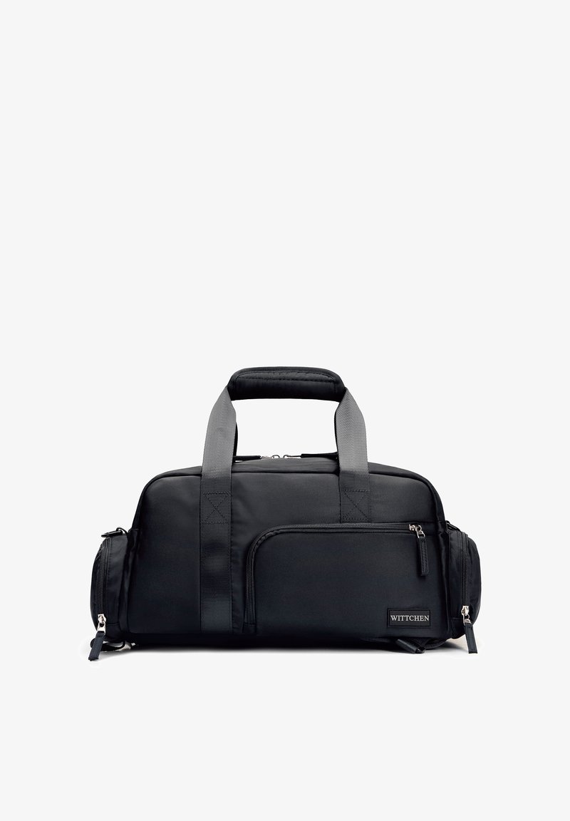 Sac de voyage rectangulaire noir avec deux poignées robustes, poche avant zippée, compartiments latéraux et étiquette de marque "WITTCHEN" dans le coin inférieur droit.