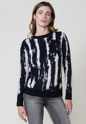 Strickpullover mit einem navyblauen und weißen abstrakten Streifenmuster, rundem Ausschnitt sowie gerippten Bündchen und Saum. Das Material wirkt weich und strukturiert.