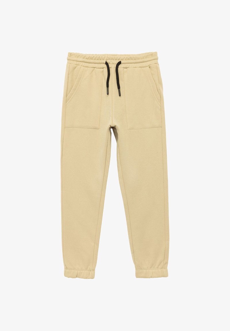 Beige Jogginghose mit elastischem Bund, schwarzem Kordelzug und zwei Fronttaschen; schmal zulaufende Beine mit genähten Bündchen an den Knöcheln.