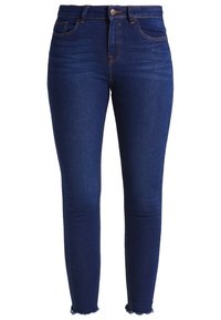 Vaqueros ajustados de mezclilla en azul oscuro, con cintura alta, diseño de cinco bolsillos y dobladillo deshilachado. Detalles de costuras clásicas en toda la prenda.