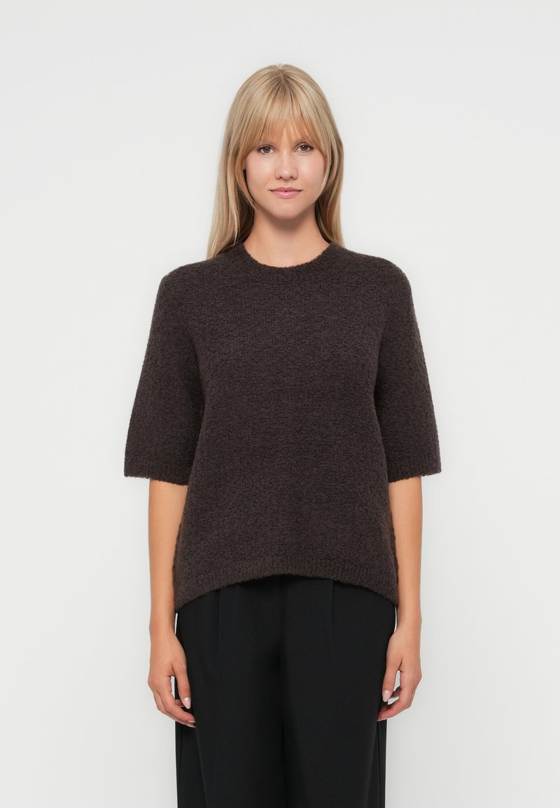 Dark brown, short-sleeve knitted sweater with a round neckline and loose fit, featuring a textured fabric and a hem that falls below the waist.