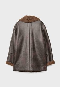 Tumma ruskea nahkatakki leveällä istuvuudella, jossa on teksturoitu ruskea lampaanvuoritettu kaulus ja kalvosimet, nähtynä takaapäin vaalealla taustalla.