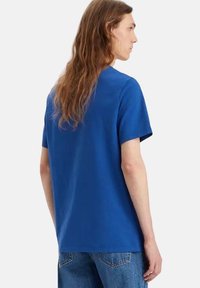 T-shirt bleu royal à manches courtes en coton avec une coupe décontractée, doté d'un col rond et de détails de couture minimalistes au dos.
