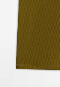 Panneau en tissu vert olive côtelé avec couture visible le long du bord inférieur sur fond blanc.