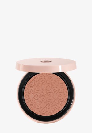 Compact rond et compact de poudre de maquillage pressée couleur pêche avec un motif embossé et un couvercle rose clair partiellement ouvert.