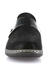 Scarpa nera slip-on con tomaia testurizzata, cinturino nero lucido e cuciture bianche a contrasto lungo la suola. Design a punta arrotondata.