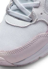 Scarpa sportiva bianca realizzata con materiali in rete e pelle, con accenti color rosa chiaro, forma arrotondata e sistema di allacciatura visibile.