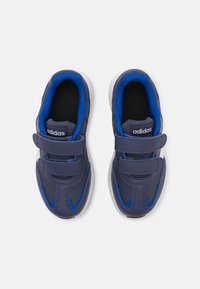 Chaussures de sport bleues et bleu marine avec des bandes Velcro, doublure en textile et semelles en caoutchouc blanc contrastant. Présentent un matériau extérieur texturé.