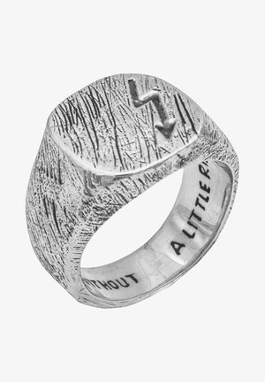 Zilveren ring met een gestructureerd oppervlak en een solide rechthoekige top met een reliëf van een naar beneden wijzend pijlsymbool. De binnenkant heeft een gravure die zegt: "EEN BEETJE."