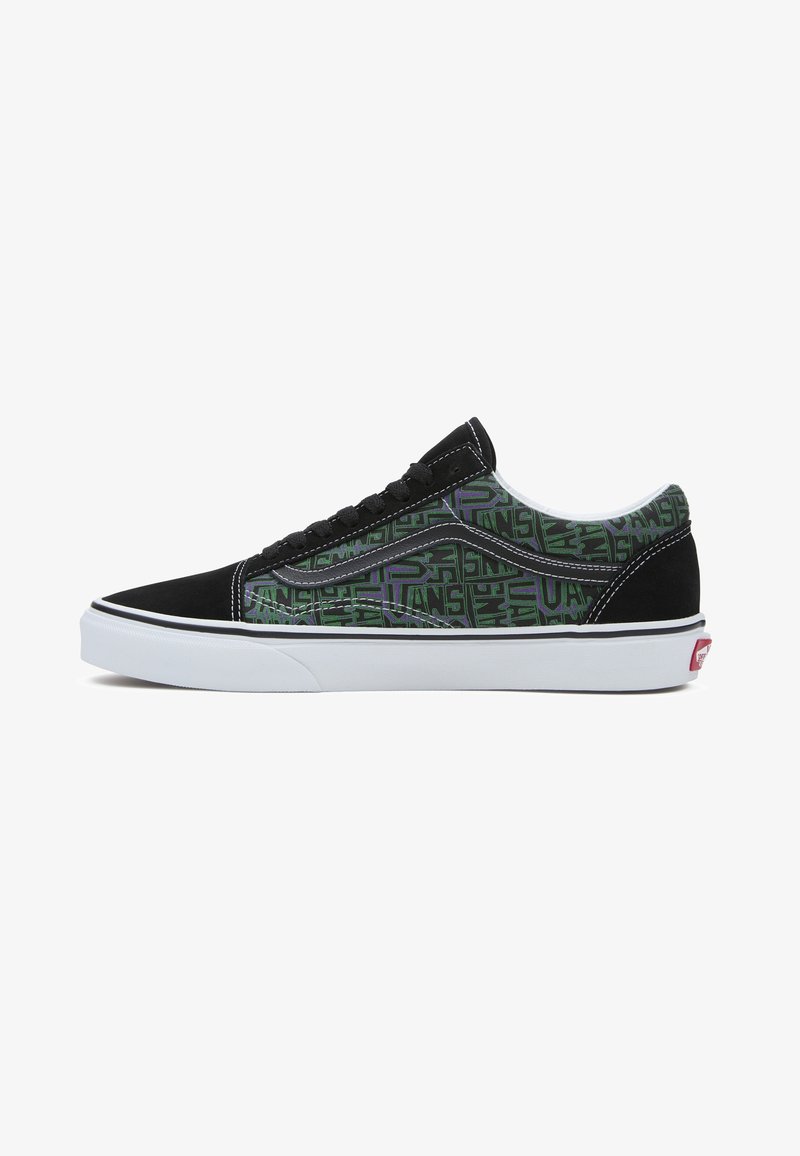 Baskets basses Vans avec bout et talon en daim noir, côtés à motif vert et violet, bande ondulée blanche et semelle en caoutchouc blanche.