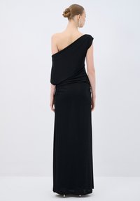 Sort, one-shoulder maxi kjole med draperet design og rynkede detaljer på siden, lavet af blødt, glat stof.