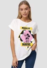 Witte t-shirt met korte mouwen, voorzien van een afgedrukte afbeelding van Mickey Mouse, omrand door een geel en roze diamantvorm met zwarte accenten.
