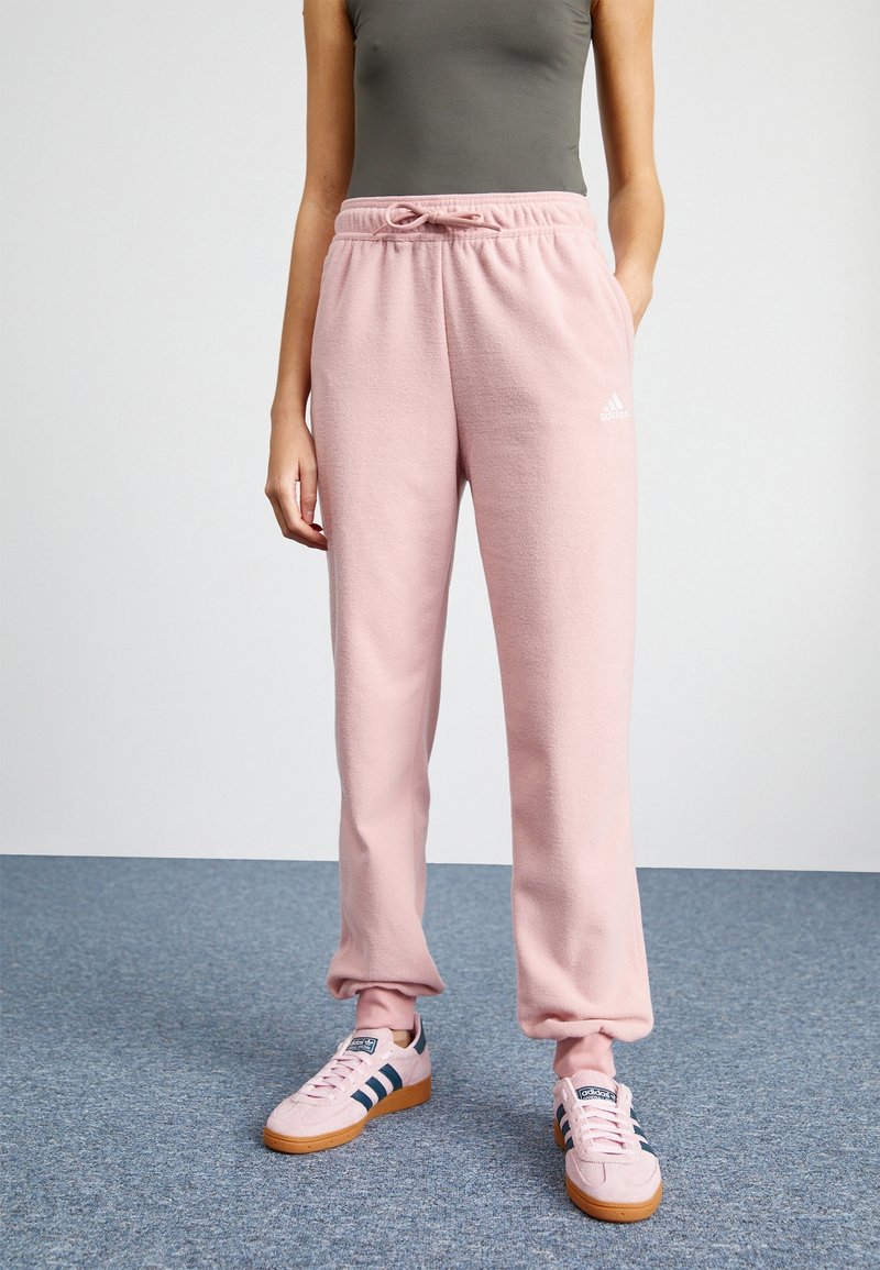 Pink fleece sweatpants with an elastic waistband, drawstring, and cuffed ankles. Features a small white logo on the left side.