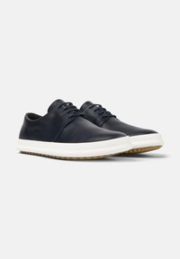 Sneakers in pelle blu navy con punta rotonda, suola intermedia bianca e suola esterna in gomma. Presentano lacci minimal e una finitura liscia.