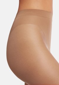 Collant beige con una texture liscia e opaca. Design a vita alta. Sottili e leggeri, adatti per essere indossati sotto i vestiti.