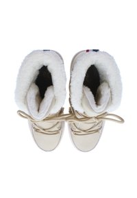 Botas beige con forro de piel de oveja blanca, cierre de cordones y suelas texturizadas. La parte superior presenta un material suave y un detalle cerca de la lengüeta.