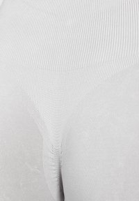 Tessuto seamless grigio chiaro con una texture a costine, caratterizzato da curve morbide e senza cuciture visibili. Progettato per una vestibilità confortevole.
