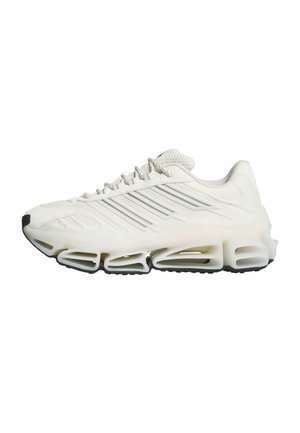 Biały sportowy sneaker z fakturowaną cholewką, wiązaniem na sznurówki oraz charakterystyczną segmentowaną podeszwą z wydrążonymi, poziomymi sekcjami.