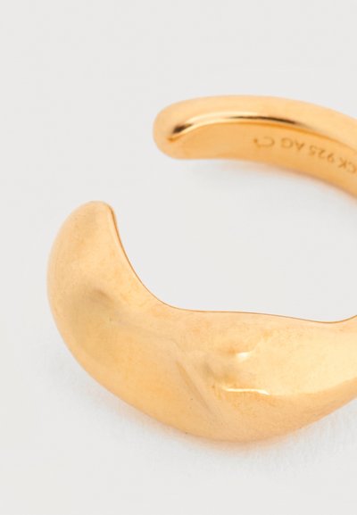 Λείο, γυαλισμένο χρυσό βραχιόλι μανσέτα με φαρδιά, καμπυλωτή μορφή και ανοιχτό άνοιγμα.