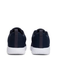 Chaussures de sport en marine foncé avec une tige en tissu texturé, des semelles blanches et une languette à l'arrière pour un enfilage facile.