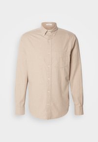 Camicia beige con bottoni in tessuto leggero a trama semplice, maniche lunghe e una sola tasca sul petto a sinistra.