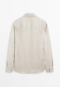Light beige long-sleeve shirt made from a textured fabric. Features a collar, button cuffs, and a curved hemline. Back view shown.