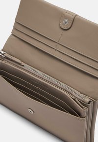 Beżowy skórzany portfel z zatrzaskiem, zamykanym na zamek przedziałem i wieloma przegródkami na karty. Prosty design z estetycznym przeszyciem i teksturowanym wykończeniem.