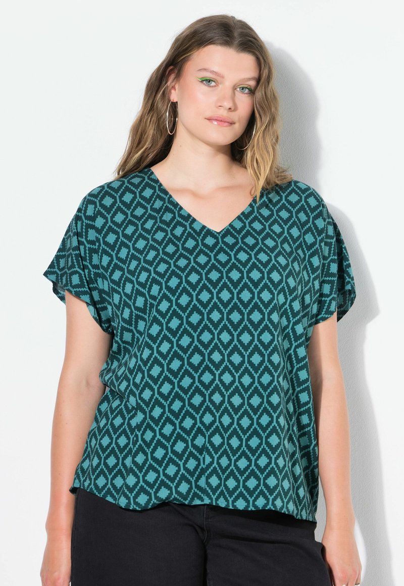 Top teal con motivo a diamante, scollatura a V, maniche corte e vestibilità ampia. Realizzato in un tessuto leggero.