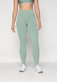 Šviesiai žali štrichiniai Legginai, pagaminti iš tamprios medžiagos su aukštu liemeniu. Yra subtilių panelių ir "Under Armour" logotipas ant apatinės kojos.