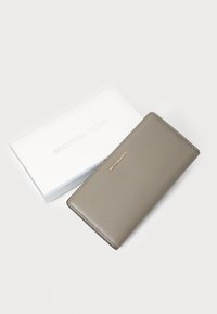 Michael Kors leather wallet in light gray with a textured finish, featuring gold hardware and a brand logo. Accompanied by a white box.