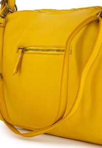 Gelbe Lederhandtasche in geschwungener Form, mit einem oberen Reißverschluss und einer vorderen Reißverschlusstasche. Glatte Struktur und genähte Akzente.