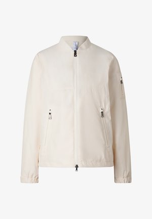 Béžová bomber bunda s předním zipem, dvěma zipy na bočních kapsách, zipem na kapse na rukávu a stojáčkovým límcem.