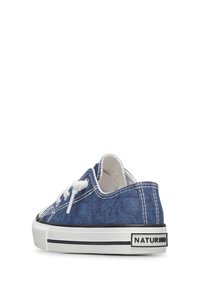 Botte en denim bleu avec des lacets blancs, une semelle blanche et une rayure noire. Présente un tissu texturé et un logo sur le talon.