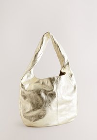 Zlata metalizirana usnjena torba hobo z mehak obliko, ukrivljenim ročajem in šivalnimi podrobnostmi. Gladka tekstura z odsevnim finishem.