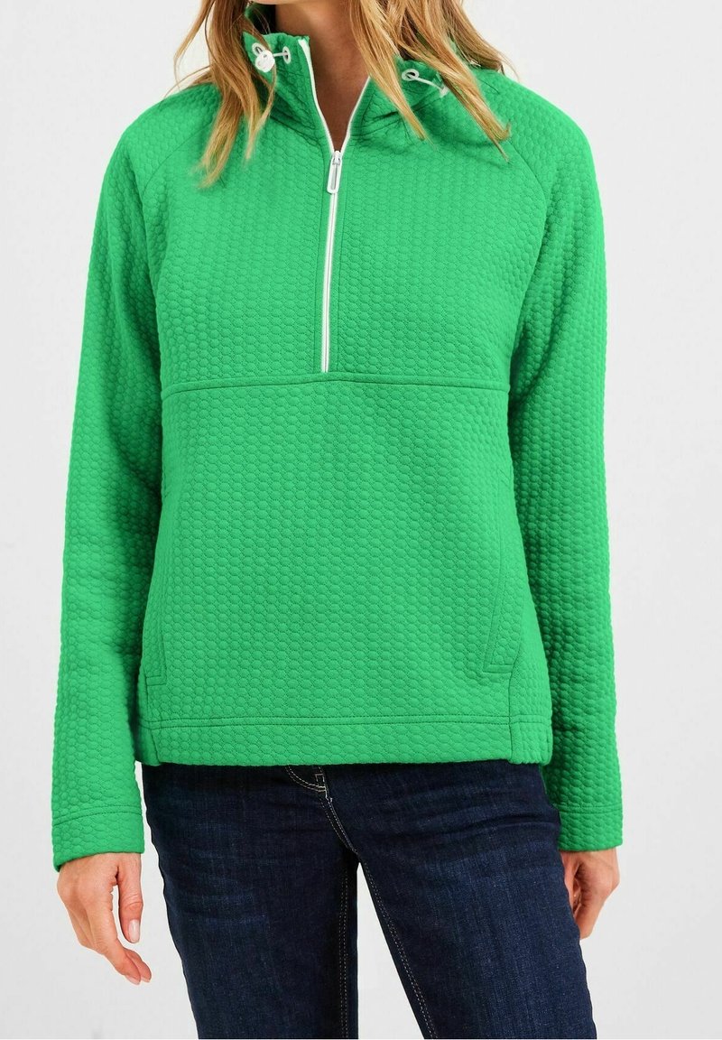 Jersey verde hecho de tela texturizada, con cremallera media, bolsillos laterales y mangas largas de corte holgado.