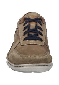 Chaussure décontractée en suède et cuir beige avec des lacets bleu marine, une languette rembourrée et des coutures contrastées. Bout arrondi et semelle texturée.