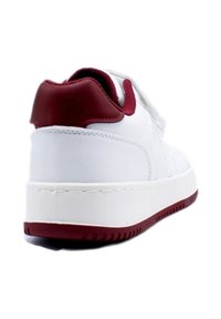 Baskets blanches avec un accent de talon bordeaux, en matériau synthétique lisse, semelle texturée et couture de couleur contrastante le long de la semelle intermédiaire.