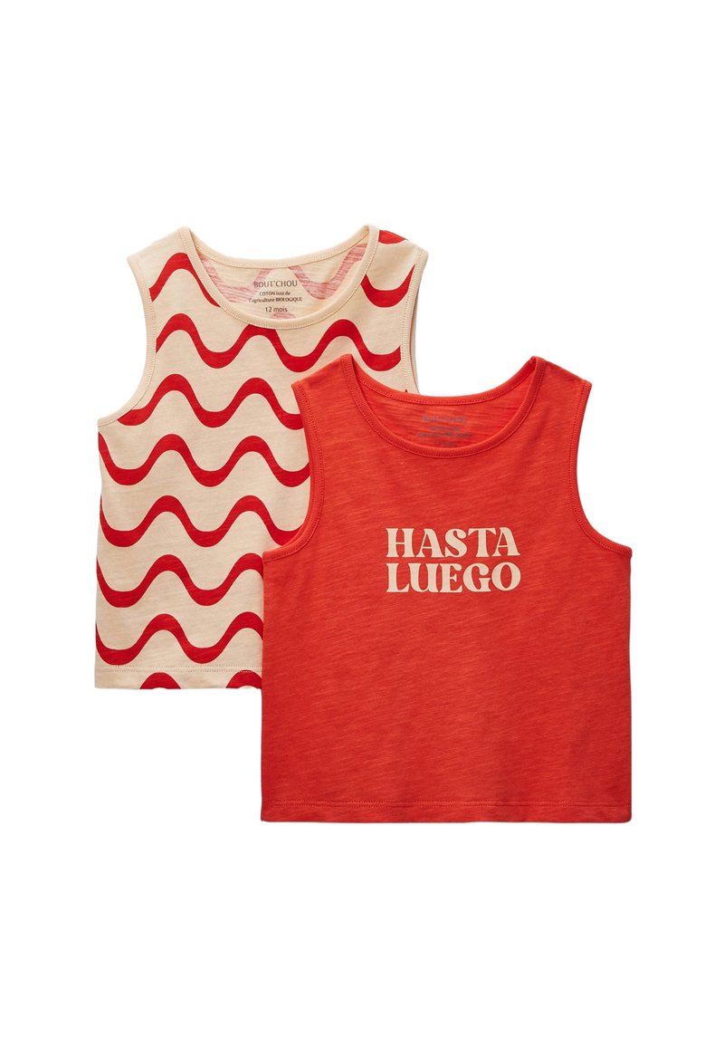 Deux tops en coton sans manches : un crème avec des lignes ondulées rouges, l'autre rouge avec "HASTA LUEGO" en lettres crème. Design simple, texture douce.