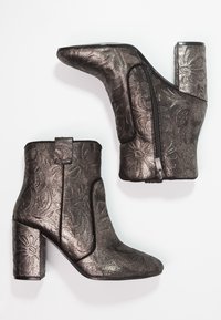 Metalické černé kotníkové boty s texturovaným květinovým vzorem, špičatou špičkou a masivním podpatkem. Zapínání na boční zip.