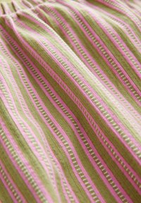 Tessuto rigato in verde e rosa, caratterizzato da linee alternate di design solidi e a motivi, con una consistenza morbida e un aspetto lavorato a maglia.