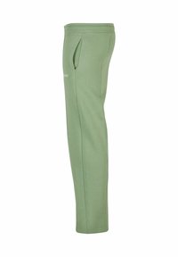 Lichtgroene sweatpants gemaakt van zachte materialen met een relaxte pasvorm, zijzakken en een elastische tailleband voor comfort.