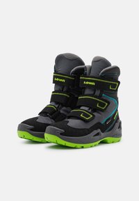 Stivali neri e grigi con suole in gomma verde, dotati di cinturini in Velcro e cuciture a contrasto blu. Progettati per resistenza e supporto.